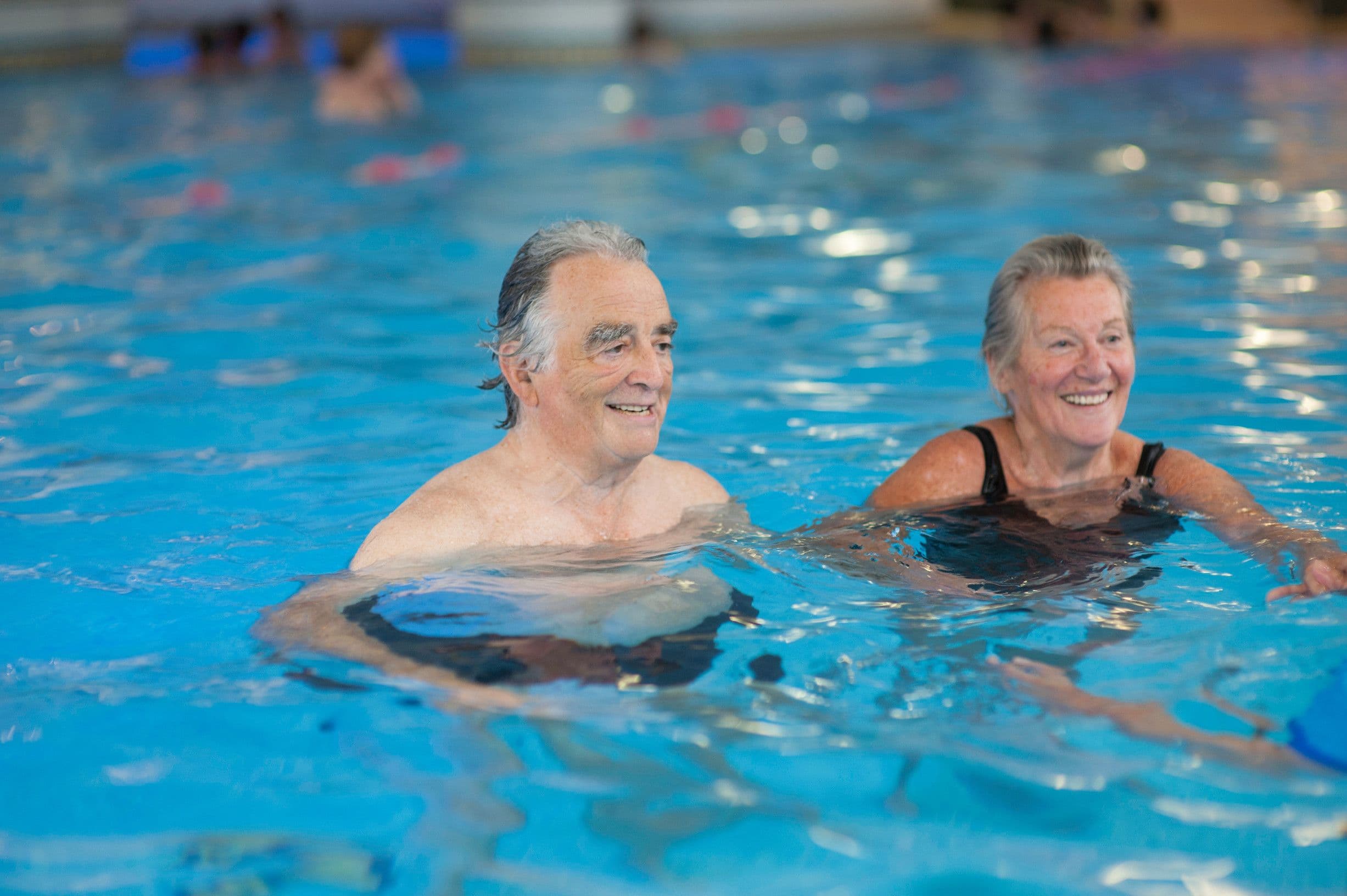 Elderly man floating in pool