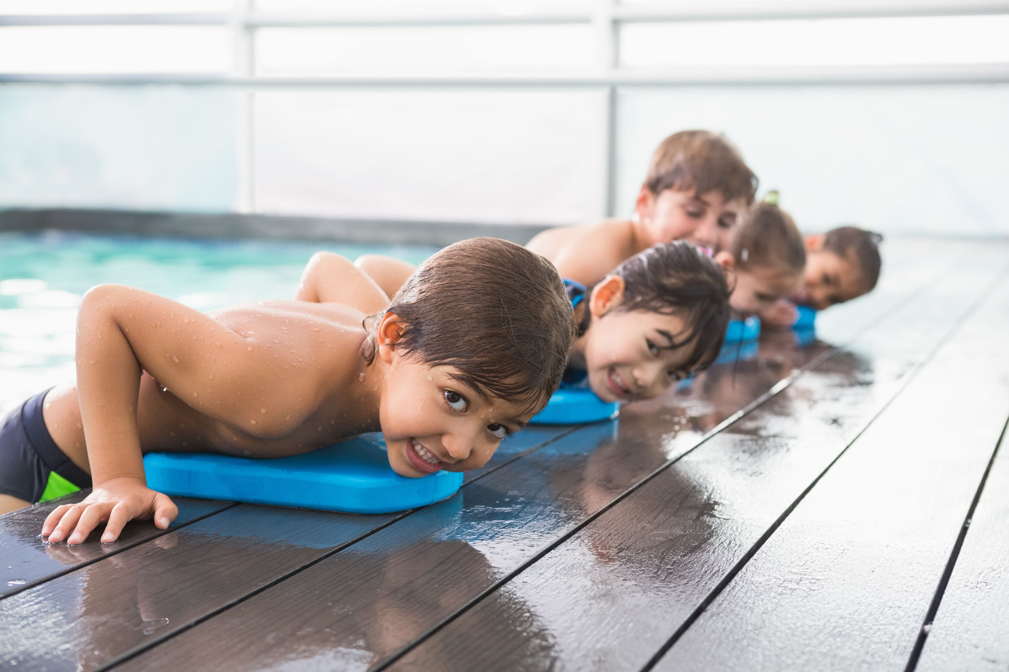 Child resting on side of pool